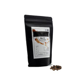 PHENIOX Kaffeebohnen Espressoblend No. 1 steht vor weißem Hintergrund. Ein kleiner Haufen Kaffeebohnen liegt daneben.